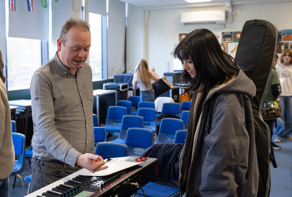 Steve Parry stood in front of a student as they look at the task sheet.
