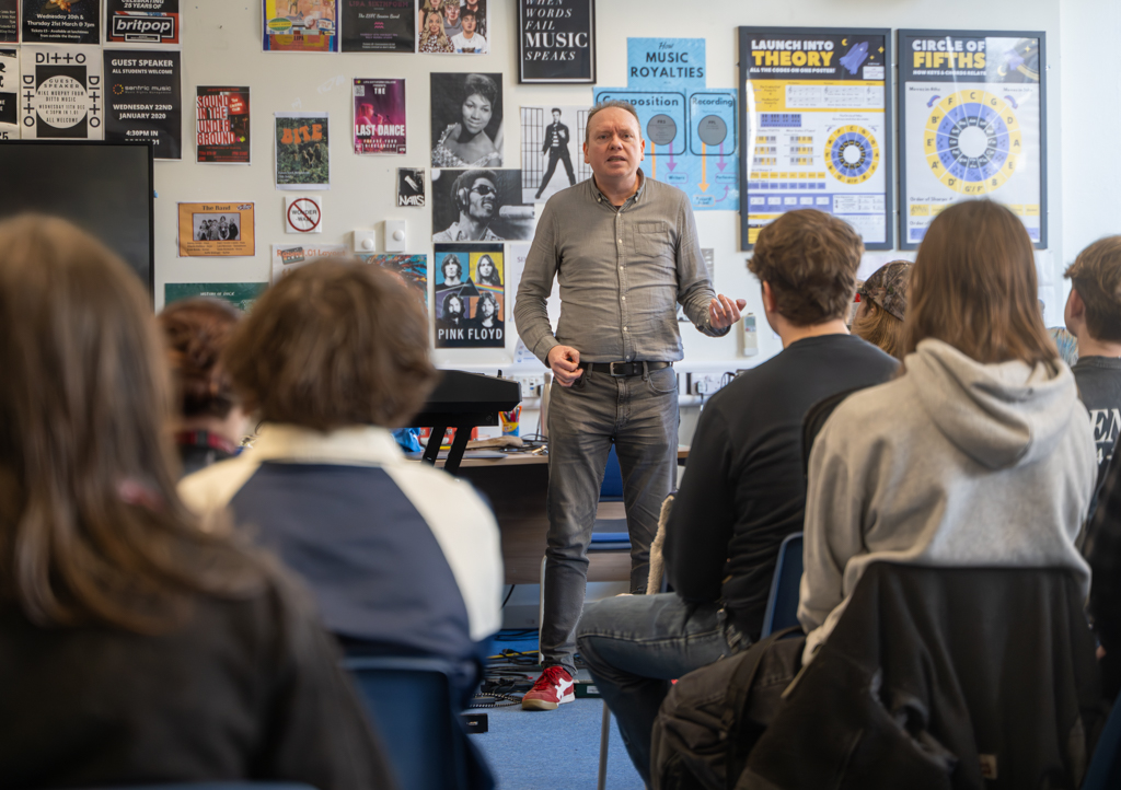 Steve parry stands in front of a busy classroom while conducting his talk.