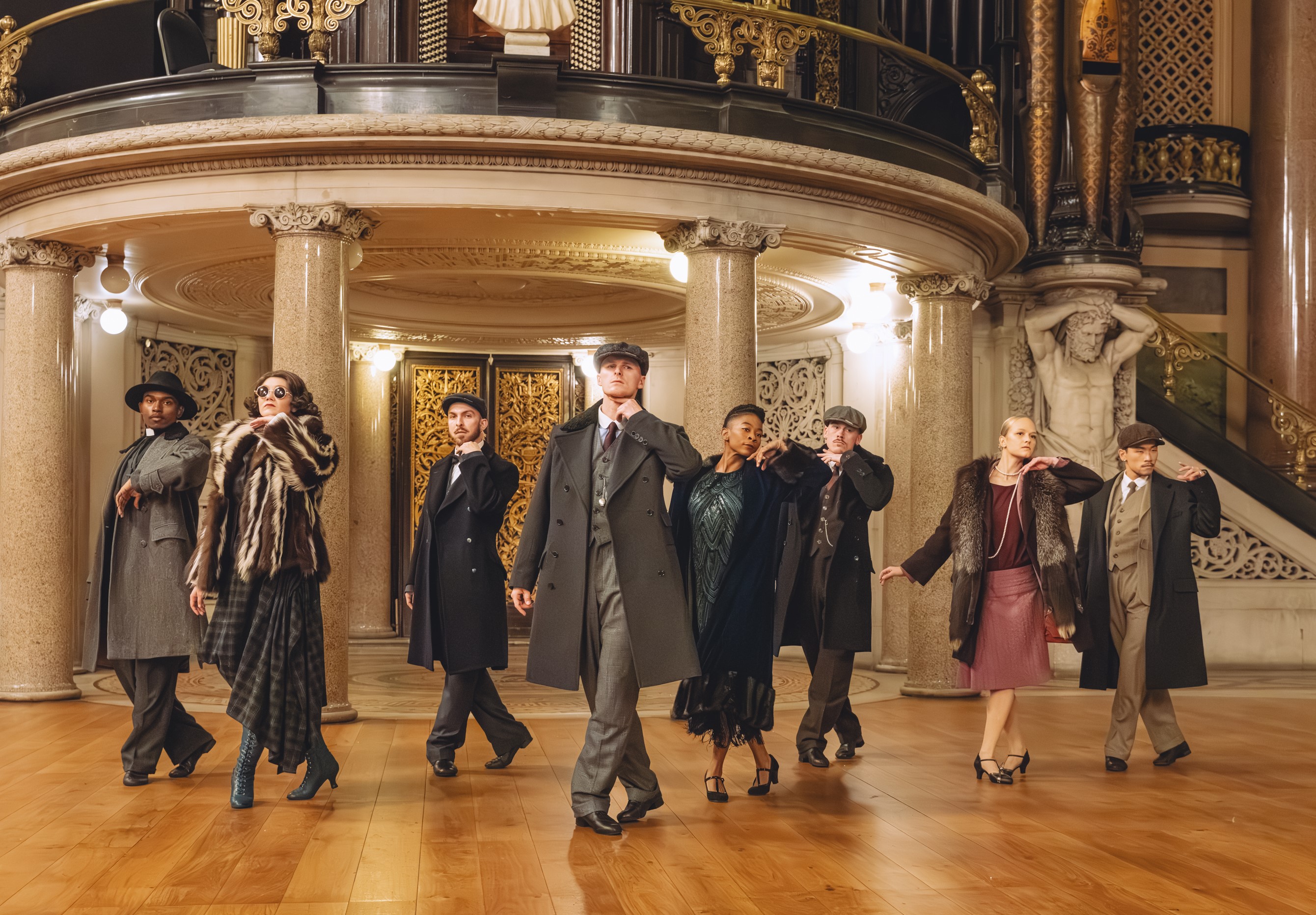 A group of actors stood in matching poses for Peaky Blinders performance. 