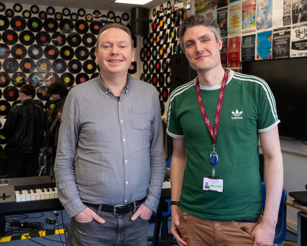 Steve Parry and Mike Roberts, Head of Music, stood in the music classroom whilst students work away behind them