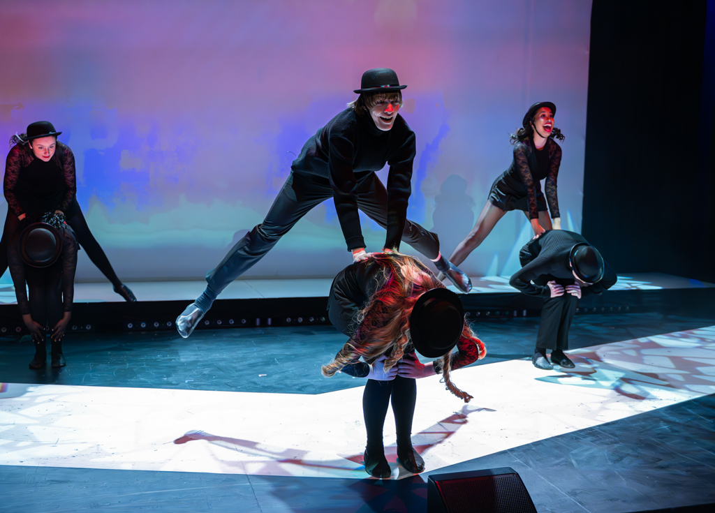 Students jumping over each other whilst one bends down.